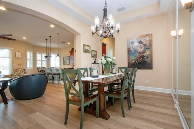 328 Siena Vista Pl, Sun City Center, FL 33573 - dining room with light wood-type flooring, arched walkways, visible vents, and baseboards
