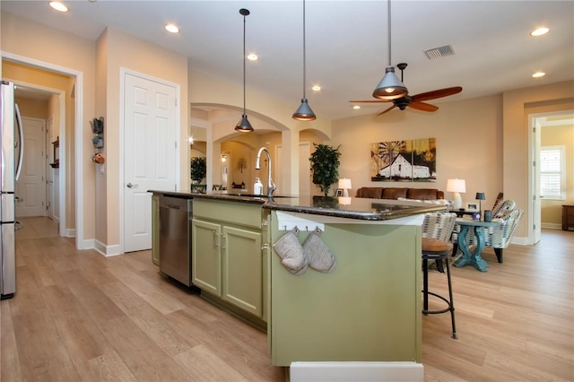 328 Siena Vista Pl, Sun City Center, FL 33573 - kitchen with visible vents, arched walkways, green cabinetry, appliances with stainless steel finishes, and a sink