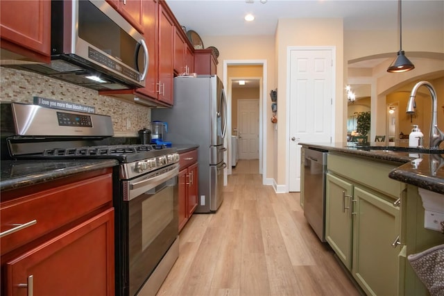 328 Siena Vista Pl, Sun City Center, FL 33573 - kitchen featuring a sink, appliances with stainless steel finishes, decorative backsplash, dark stone counters, and light wood finished floors