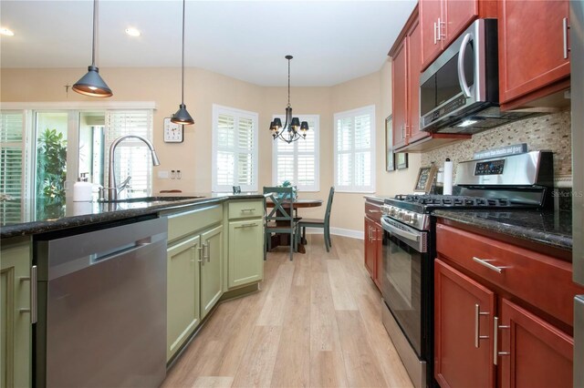 328 Siena Vista Pl, Sun City Center, FL 33573 - kitchen with tasteful backsplash, a sink, appliances with stainless steel finishes, light wood finished floors, and pendant lighting