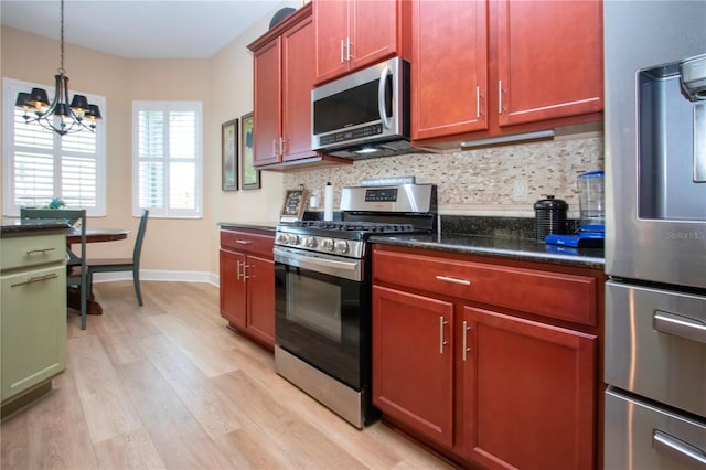 328 Siena Vista Pl, Sun City Center, FL 33573 - kitchen featuring decorative light fixtures, an inviting chandelier, stainless steel appliances, light wood-type flooring, and backsplash