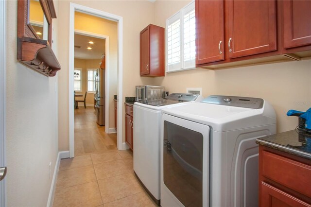 328 Siena Vista Pl, Sun City Center, FL 33573 - washroom with baseboards, cabinet space, washing machine and clothes dryer, and light tile patterned flooring