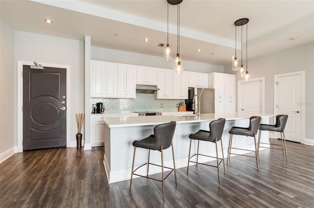 kitchen with decorative light fixtures, a large island, light countertops, decorative backsplash, and white cabinets