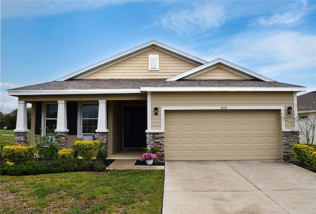 craftsman-style house featuring an attached garage, covered porch, stone siding, concrete driveway, and roof with shingles