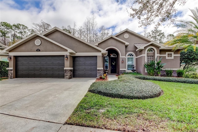 ranch-style house with stucco siding, concrete driveway, an attached garage, a front yard, and stone siding