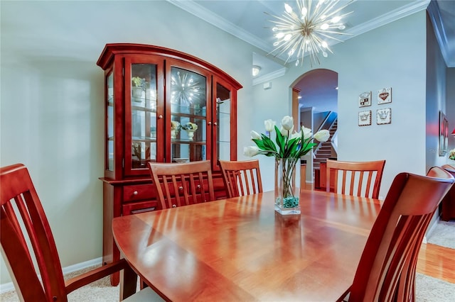 dining space with a chandelier, arched walkways, crown molding, and baseboards