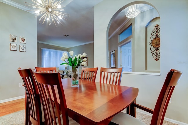 dining area with baseboards, visible vents, wood finished floors, crown molding, and a chandelier