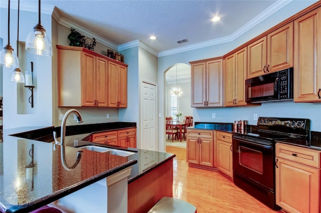 kitchen with light wood finished floors, visible vents, ornamental molding, black appliances, and a sink