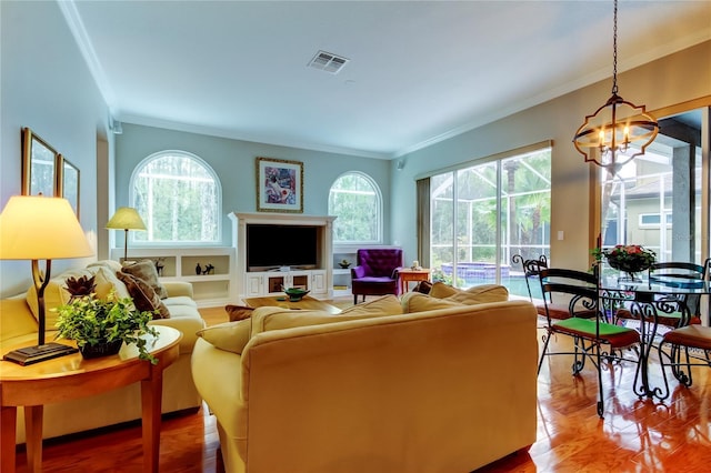 living room featuring an inviting chandelier, plenty of natural light, visible vents, and ornamental molding