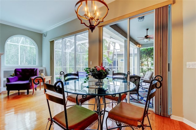 dining space with a healthy amount of sunlight, light wood-style flooring, baseboards, and crown molding