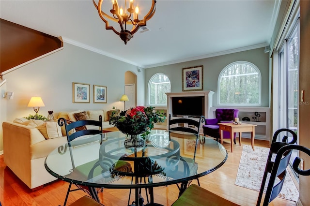 dining area featuring crown molding, visible vents, arched walkways, and wood finished floors