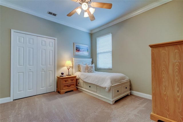 carpeted bedroom featuring a ceiling fan, baseboards, visible vents, a closet, and crown molding