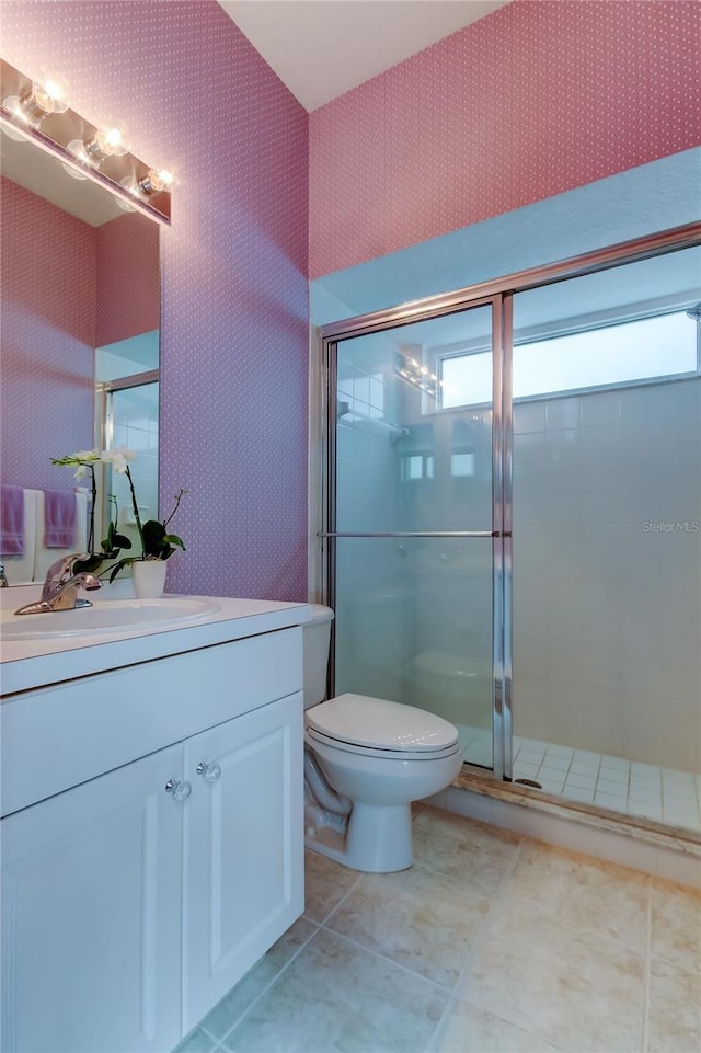 bathroom featuring toilet, a stall shower, vanity, tile patterned flooring, and wallpapered walls