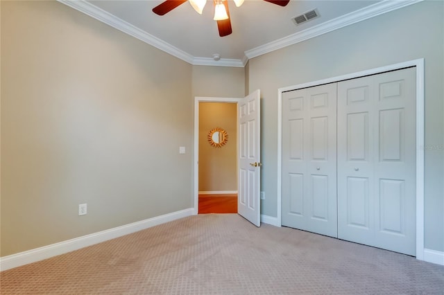 unfurnished bedroom with light colored carpet, visible vents, baseboards, ornamental molding, and a closet