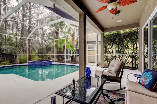 view of pool with a pool with connected hot tub, a ceiling fan, a patio area, a lanai, and an outdoor living space