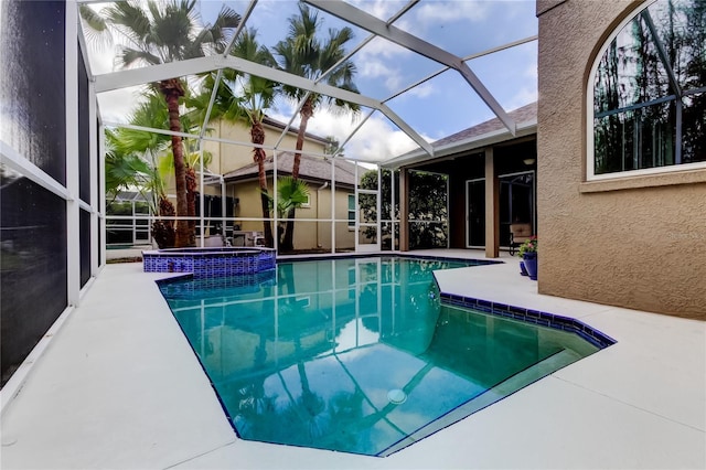 view of swimming pool with a patio area, a pool with connected hot tub, and glass enclosure