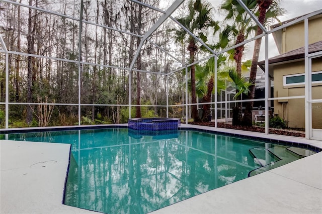 view of swimming pool with glass enclosure, a patio area, and a pool with connected hot tub