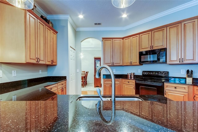 kitchen with visible vents, arched walkways, crown molding, black appliances, and a sink