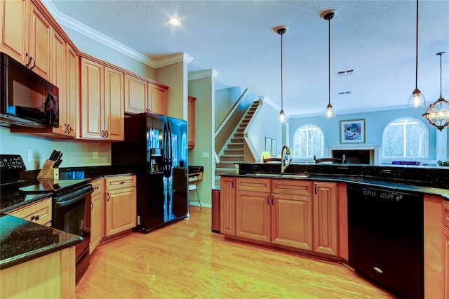 kitchen featuring pendant lighting, crown molding, light wood-style flooring, a sink, and black appliances