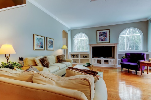 living room with ornamental molding, arched walkways, a wealth of natural light, and wood finished floors