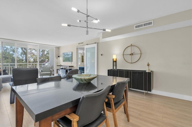 dining room featuring baseboards, light wood-style flooring, visible vents, and an inviting chandelier