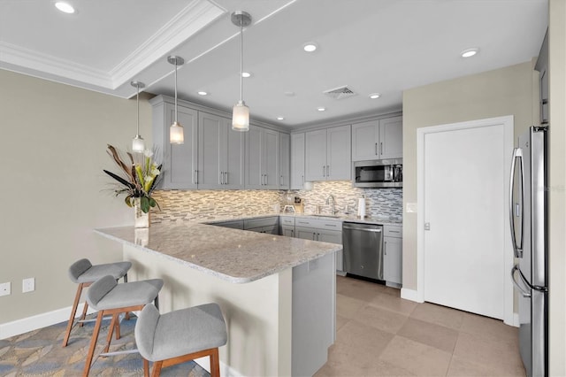 kitchen featuring gray cabinetry, a peninsula, visible vents, ornamental molding, and appliances with stainless steel finishes