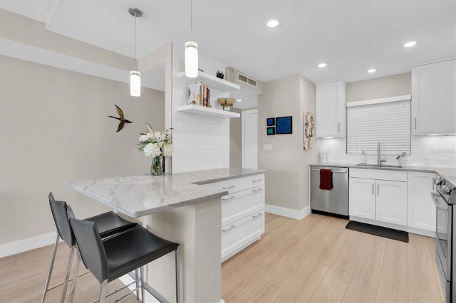 kitchen with tasteful backsplash, visible vents, appliances with stainless steel finishes, white cabinetry, and a sink