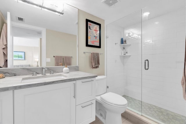 full bath with toilet, vanity, a shower stall, and visible vents