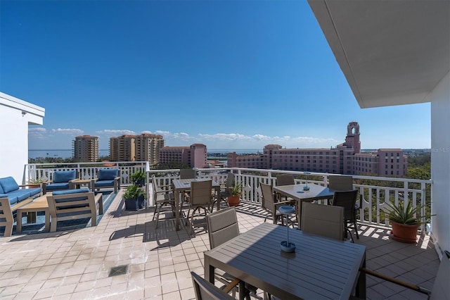 view of patio with outdoor dining space, a view of city, and an outdoor hangout area