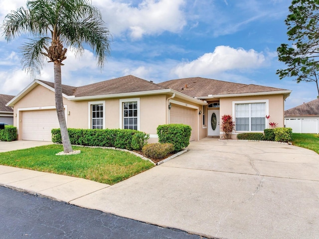 single story home featuring a front lawn, a garage, driveway, and stucco siding