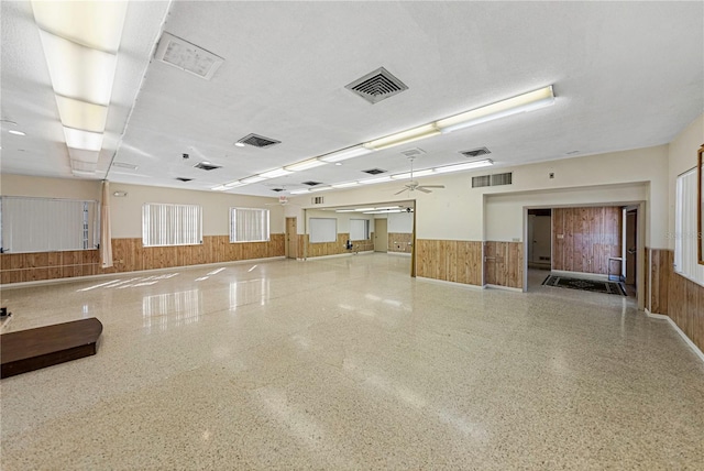 misc room featuring a wainscoted wall, visible vents, and wood walls