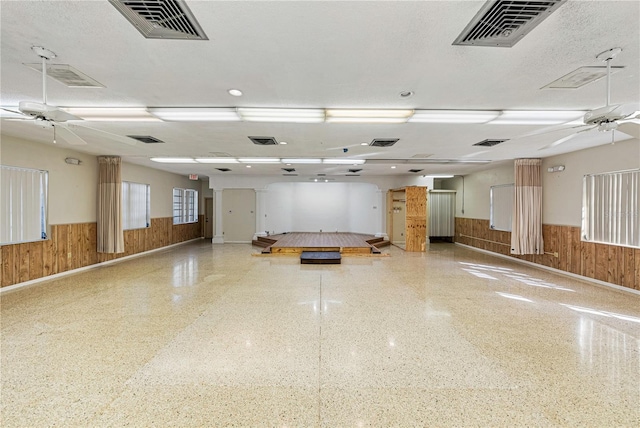 garage featuring a wainscoted wall, visible vents, and wood walls