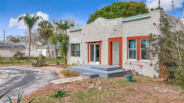 rear view of property featuring a deck and stucco siding