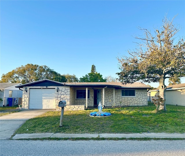 single story home featuring a front lawn, stone siding, driveway, and an attached garage