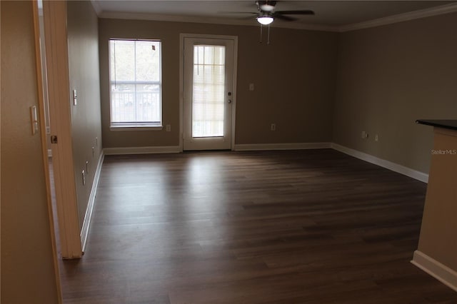 interior space with dark wood-style floors, ceiling fan, baseboards, and crown molding