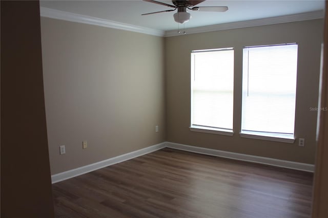 unfurnished room with dark wood-style floors, plenty of natural light, ornamental molding, and baseboards