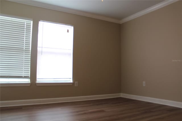 unfurnished room featuring ornamental molding, baseboards, and dark wood-style floors