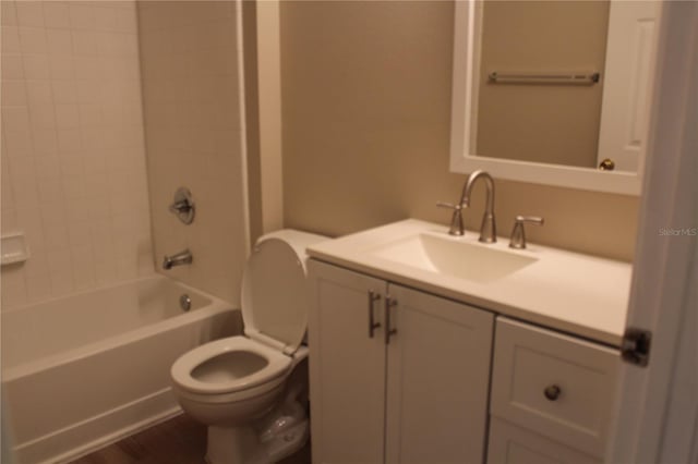 bathroom featuring toilet, bathtub / shower combination, wood finished floors, and vanity