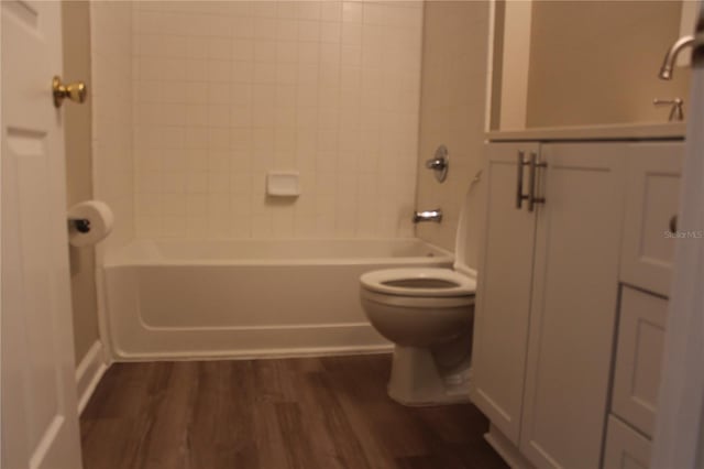 bathroom with shower / bath combination, toilet, and wood finished floors