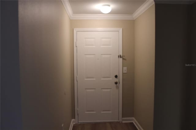 entryway with dark wood finished floors, crown molding, and baseboards