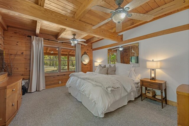 bedroom with ceiling fan, wood walls, beam ceiling, light carpet, and wooden ceiling