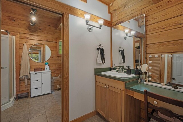 bathroom featuring tile patterned floors, wooden walls, a shower stall, and vanity