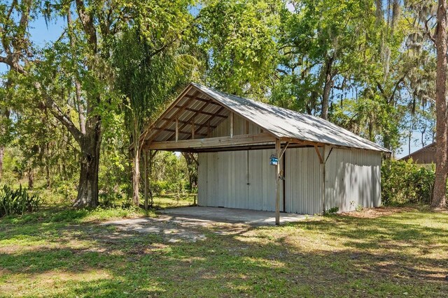 view of outdoor structure with an outdoor structure, a carport, and driveway