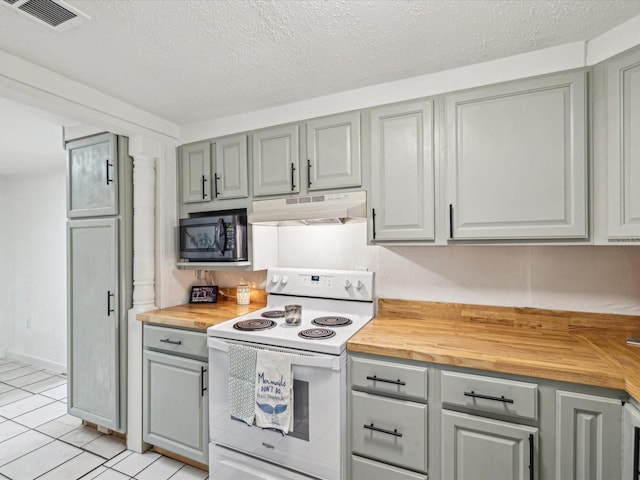 kitchen featuring under cabinet range hood, butcher block counters, black microwave, and electric stove