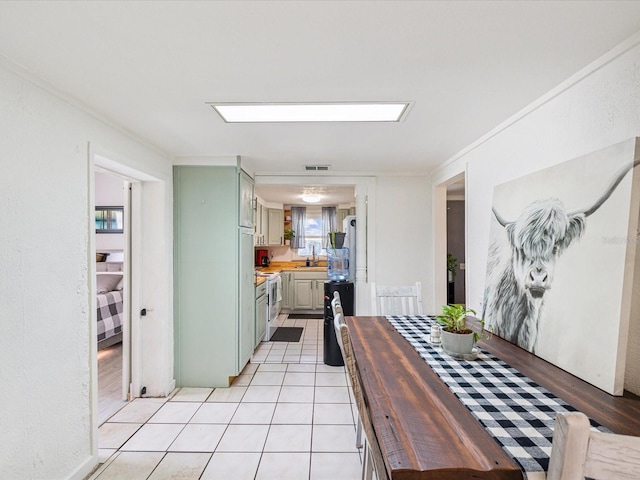 dining space with ornamental molding, visible vents, and light tile patterned floors