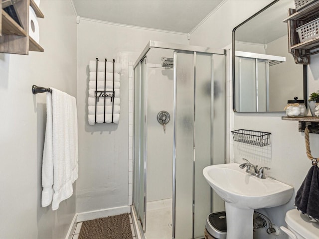 full bath with toilet, a stall shower, baseboards, and ornamental molding