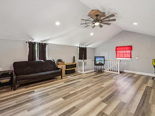 living area featuring lofted ceiling, wood finished floors, an upstairs landing, and recessed lighting