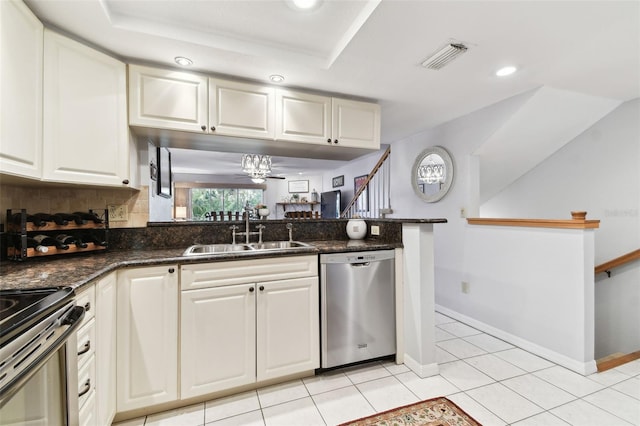 kitchen with visible vents, dark stone counters, stainless steel appliances, white cabinetry, and a sink