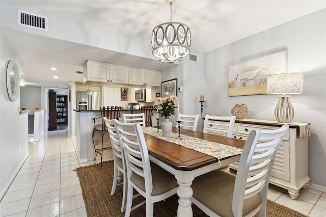 dining space featuring visible vents, a notable chandelier, baseboards, and light tile patterned floors