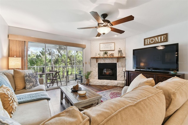 living area featuring light wood-style floors, a fireplace, and a ceiling fan